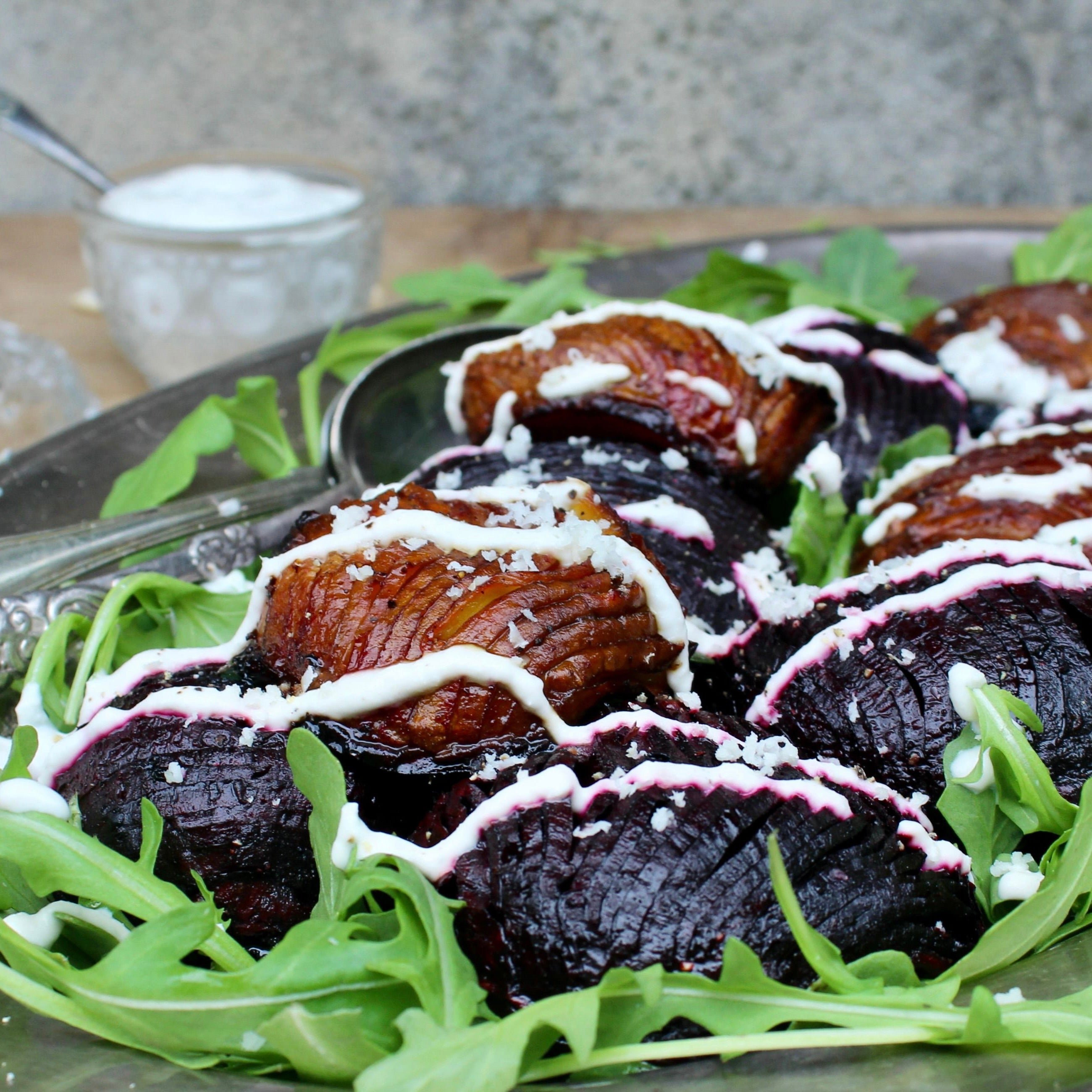 Hasselback beder | Hasselback beder med peberrods-cashewcreme og rucola